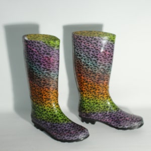 Peut inclure: Une paire de bottes de pluie noires avec un motif léopard multicolore. Les bottes ont une pointe arrondie et une tige haute.