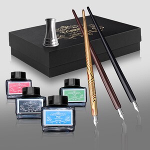 May include: A calligraphy set featuring a black box with gold lettering, three pens, ink bottles in red, black, green, and blue, and a silver pen holder. The pens have wooden and black handles.