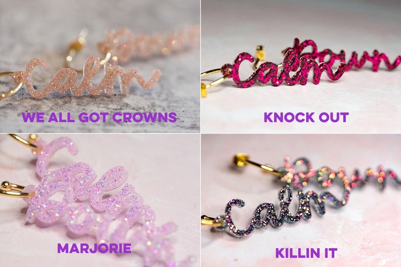 May include: Four pairs of gold hoop earrings with the word "calm" written in sparkly script. The earrings are in four different colors: pink, red, purple, and gray. The text below each pair of earrings reads: "We all got crowns", "Knock out", "Marjorie", and "Killin it".