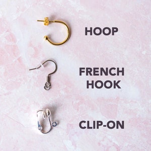 May include: Three different types of earring findings: a gold hoop, a silver french hook, and a silver clip-on.