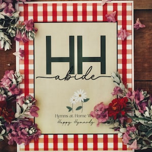 May include: A rectangular print featuring a red and white gingham border surrounding a cream-colored center. The text HH, abide, Hymns at Home, and Happy Hymnody are printed in black. A small illustration of two white daisies is centered below.