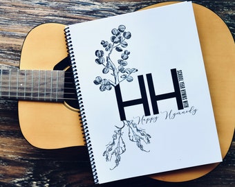 May include: A white spiral bound notebook with the text "School Year Hymns with Happy Hymnody" and a black and white illustration of a plant with two large "H" letters.