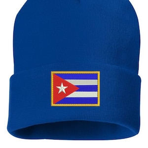May include: A blue knitted beanie with a white star and red and white stripes on the front, resembling the Cuban flag.