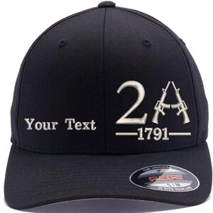 May include: Black baseball cap with a white embroidered design that says "2A - 1791" and "Your Text". The cap has a black Flexfit logo on the back.