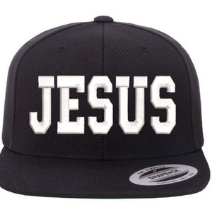 May include: Black baseball cap with a white embroidered "JESUS" on the front. The cap has a black brim and a black adjustable strap.