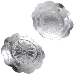 May include: Two silver metal decorative embellishments with a scalloped edge and a raised floral design in the centre.