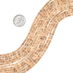 May include: A strand of light brown and beige shell beads. The beads are square shaped and have a striated pattern. The beads are approximately 6mm in size.