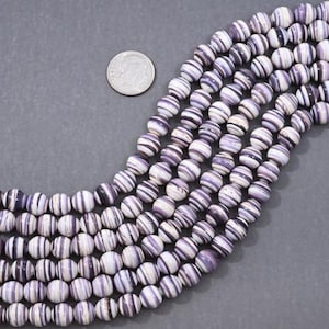 May include: A strand of round, white and purple striped beads. The beads are approximately 10mm in diameter.
