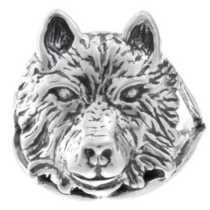 May include: A silver ring with a detailed wolf head design. The wolf's face is intricately carved, showing fur texture, eyes, nose, and ears. The ring has a polished finish, highlighting the details of the wolf's features.