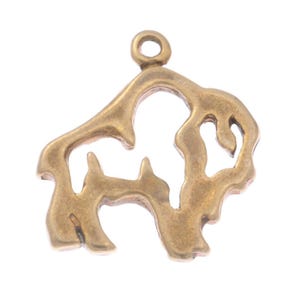 May include: A bronze-coloured metal charm in the shape of a bison. The charm has a loop at the top for attaching to a necklace or bracelet. The bison is depicted in a stylized, open design.