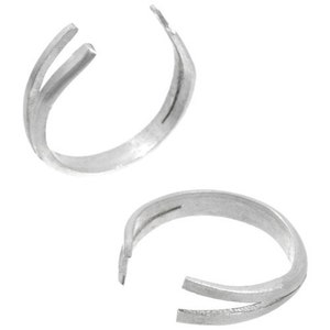 May include: Two silver ring size adjusters. Each adjuster is a thin, open circle of metal with a split on one side. The split allows the ring to be adjusted to fit different finger sizes.