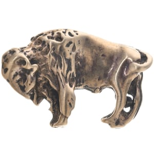 May include: A detailed bronze sculpture of a bison, standing on all four legs with its head lowered. The sculpture is highly textured, with a rough, almost weathered finish.