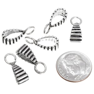 May include: Six silver-toned metal pendant bails with a ridged design. The bails are approximately the size of a UK ten pence coin.