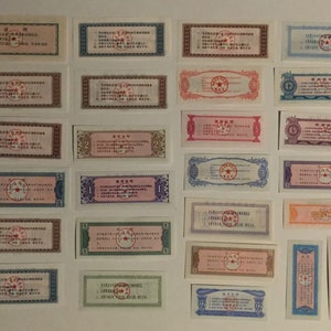 May include: A collection of vintage Chinese paper money featuring a red star and Chinese text. The denominations include 1, 2, 5, and 12.