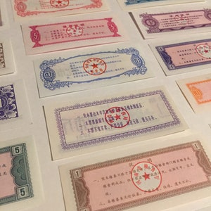 May include: A collection of vintage Chinese ration coupons with red star seals. The coupons are printed in various colors, including pink, blue, and green. The text on the coupons is in Chinese.
