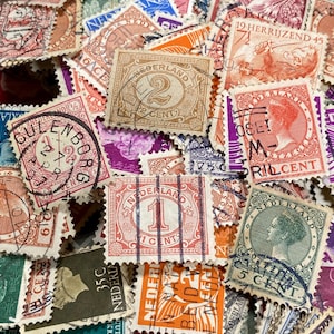 May include: A close-up of a pile of antique postage stamps in a variety of colours. The stamps display detailed designs, portraits, and text, with denominations such as "2 CENT" and "5 CENT".