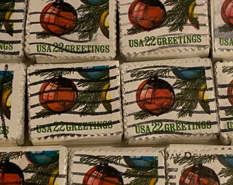 May include: A collection of vintage Christmas stamps featuring a red ornament, pine branches, and the text "USA 22 GREETINGS".