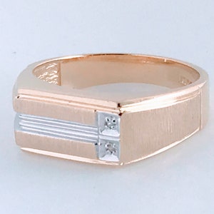 May include: A gold and silver two-tone ring with a square face and two small diamonds.