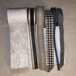 May include: Assortment of ribbon trims in various patterns and colors, including white lace, black and white striped, beige with white polka dots, black and white gingham, and blue with white trim.