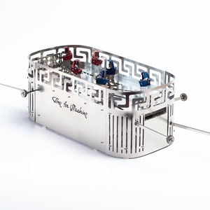 May include: A silver metal model of a chariot with a Greek key design around the top. The chariot has a clear plastic interior with small red and blue objects inside. The chariot has two axles with wheels and the text "Time for Machine" is inscribed on the side.