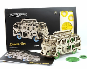 Könnte beinhalten: Ein Holzmodellbausatz eines Vintage-Wohnmobils namens "Dream Van" mit 109 Teilen. Der Bausatz enthält eine Anleitung, eine grüne Spirale und gelbe Kreise.