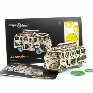 May include: A wooden model kit of a vintage camper van, called "Dream Van", with 109 pieces. The kit includes instructions, a green spiral, and yellow circles.