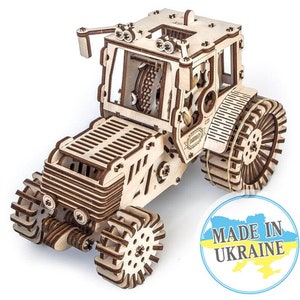 May include: A wooden model kit of a tractor with intricate details and working gears. The model is made of natural wood and has a rustic brown colour. The tractor has a large rear wheel and smaller front wheels. The model is labelled "Made in Ukraine".