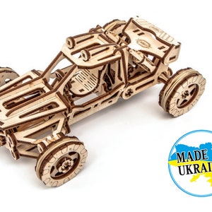 May include: A wooden model kit of a dune buggy, featuring a detailed design and intricate parts. The model is crafted from natural wood and is ready to be assembled. The kit includes instructions and all the necessary parts. Made in Ukraine.