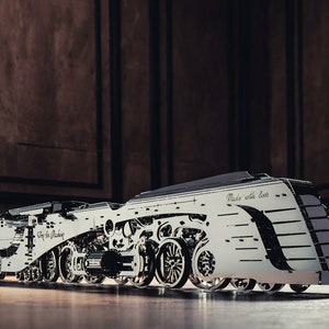 May include: A detailed model of a silver steam locomotive with black accents. The model is made of metal and has intricate details, including wheels, gears, and a smokestack. The model is on a wooden surface and has the text "Made with love" on the side.