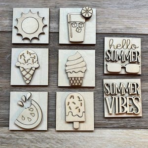 May include: Nine wooden summer-themed cutouts. Designs include a sun, a drink with ice and a lemon slice, an ice cream cone, a soft serve ice cream, a watermelon slice, a popsicle, and the phrases "hello SUMMER" and "SUMMER VIBES".