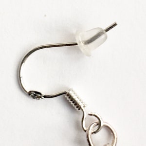 May include: Silver earring with a spring clasp and a clear rubber stopper.