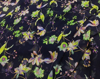 May include: A dark blue fabric with a floral print featuring yellow, green, and pink flowers. The fabric has a sheer, translucent quality.
