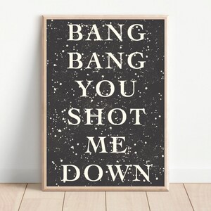 May include: Black and white typography print with the text "Bang Bang You Shot Me Down" on a black background with white speckles.