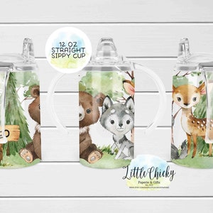 May include: A 12 ounce clear plastic sippy cup with a straw and two handles. The cup has a woodland animal design with a bear, wolf, and deer. The cup is personalized with the name "Theo".