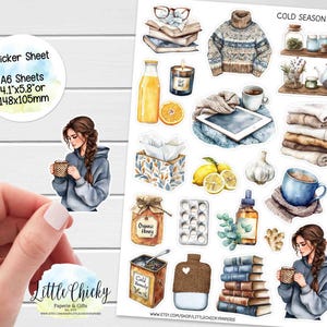 Könnte beinhalten: Ein Stickerbogen mit Illustrationen von Artikeln für die kalte Jahreszeit. Enthält einen Pullover, Bücher, Tee, Honig, Zitronen und eine Frau, die eine Tasse hält. Der Bogen ist mit "A6 Sheets 105x148mm" beschriftet.