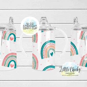May include: A set of three 12 ounce clear plastic sippy cups with a rainbow and heart design. The cups have a straw and a handle. The text "12 OZ STRAIGHT SIPPY CUP" is on a white circle.