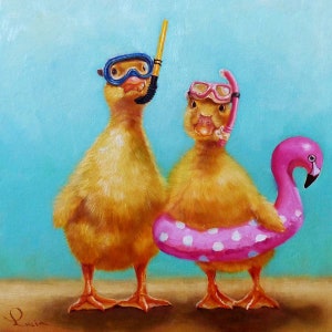 May include: Two yellow ducklings wearing goggles and snorkels, one is holding a pink flamingo pool float. The ducklings are on a sandy beach with a blue sky in the background.