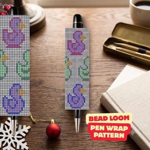 Könnte beinhalten: Ein schwarzer Stift mit einem Perlenwebmuster, das ein wiederkehrendes Design aus violetten und grünen Enten auf hellgrauem Grund zeigt. Das Muster besteht aus kleinen, gleichmäßigen Perlen in einem Raster, die eine pixelige Optik erzeugen.