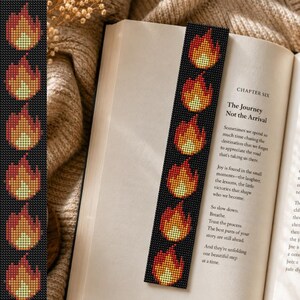 May include: A rectangular beaded bookmark featuring a repeating pattern of stylized flames in shades of red, orange, and yellow against a solid black background. The flames are arranged vertically along the length of the narrow, flat accessory.