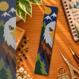 May include: A rectangular beaded bookmark featuring a pixelated design of a bald eagle head against a dark blue sky with a yellow sun and white mountain peaks. The lower portion displays green pine trees and brown eagle feathers.
