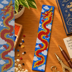 May include: A rectangular beaded bookmark featuring a long, winding red and yellow dragon design against a blue background with white clouds. The beadwork is crafted in a pixelated style, showcasing a vibrant dragon motif in a vertical orientation.