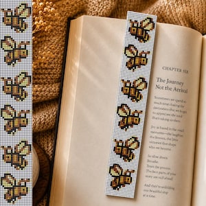 May include: A rectangular bookmark featuring a repeating pixel art pattern of yellow and brown bees on a light gray background. The bookmark is placed inside an open book with visible text, including the heading Chapter Six, The Journey Not the Arrival.