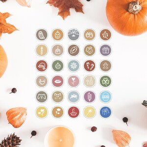 May include: A set of 36 colourful round icons with white outlines of various holiday and seasonal themes. The icons are arranged in a grid pattern on a white background with autumnal decorations such as pumpkins and leaves.