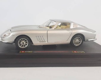 Peut inclure: Modèle réduit argenté à l'échelle 1/18 d'une Ferrari 275 GTB/4, une voiture de sport italienne classique, présentée sur une base noire.