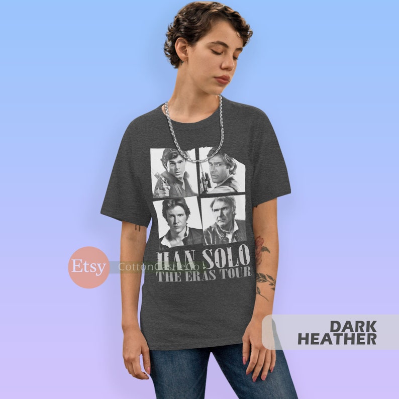 May include: Dark heather grey t-shirt featuring a collage of four images of Han Solo from different Star Wars movies. The text "Han Solo The Eras Tour" is printed below the images.