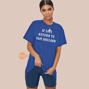May include: A royal blue t-shirt with the text "IF LOST RETURN TO TOM HOLLAND" printed in white.