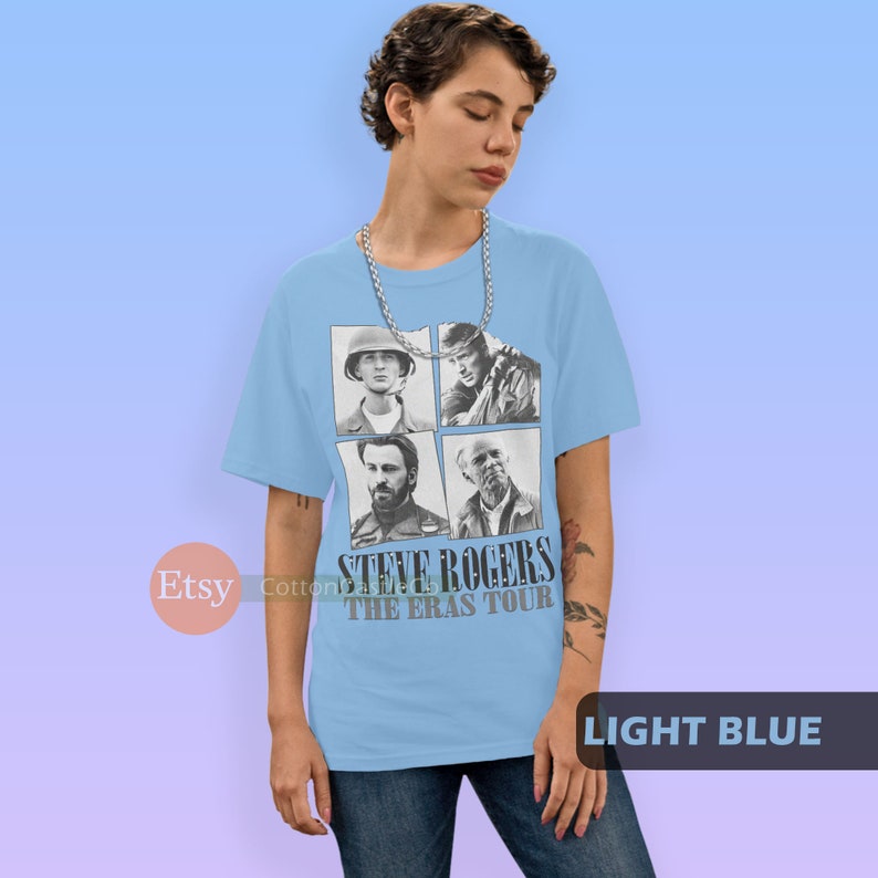 May include: Light blue t-shirt with a black and white image of Steve Rogers from the Marvel Cinematic Universe. The image shows four different versions of Steve Rogers, including his appearance in Captain America: The First Avenger, Captain America: The Winter Soldier, Captain America: Civil War, and Avengers: Endgame. The text "Steve Rogers The Eras Tour" is printed below the image.