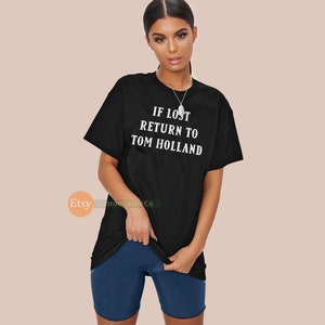 May include: Black t-shirt with white text that reads "IF LOST RETURN TO TOM HOLLAND".