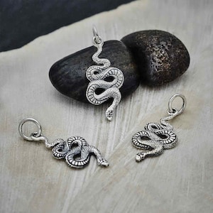 May include: Three silver snake charms with detailed scales. The charms are hanging from jump rings and are ready to be added to a necklace or bracelet.