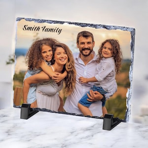May include: A slate photo frame featuring a family portrait of a man, woman, and two children. The frame has a rustic, natural appearance and is engraved with the text "Smith Family".